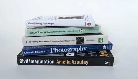 Stack of six photography and visual theory books arranged in a tilted pile against a white background.