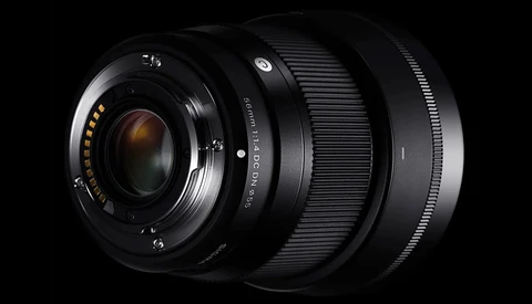 Three black camera lenses arranged in a row against a black background, showing their front glass elements and focusing rings.