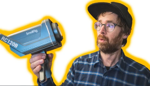 Photographer holding a blue thermal imaging camera with yellow border outline.