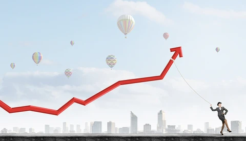 Illustration of businessman pulling a red upward trending arrow while standing on a platform above a city skyline.