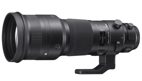 Black telephoto lens with focus ring and tripod collar against white background.