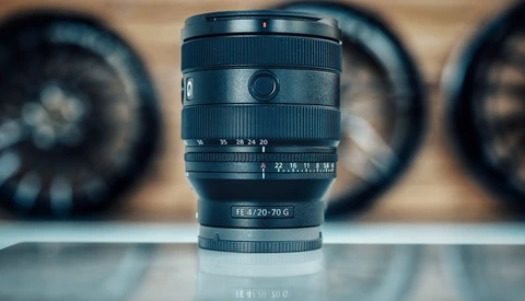 Sony FE 3.5/20-70 G zoom lens in sharp focus with blurred lenses in background.