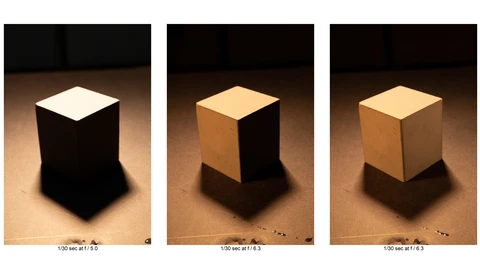 Three white cubes under different lighting conditions showing aperture and exposure variations.