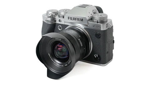 Fujifilm X-T5 mirrorless camera with attached wide-angle lens and hood, silver and black finish.