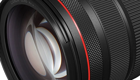 Close-up cross-section of a camera lens showing internal glass elements and a red accent ring.
