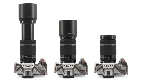 Three film camera bodies with progressively longer telephoto lenses mounted on top, arranged left to right in descending size order.