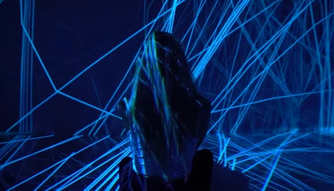 Silhouetted figure surrounded by intersecting blue neon lines in a digital environment.