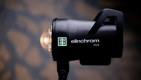 Elinchrom Five monolight with dome diffuser against blurred background.