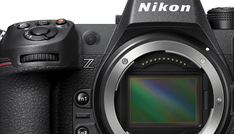 Nikon Z mirrorless camera with mount open, showing sensor with rainbow-colored dust spots.