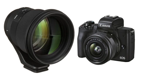 Canon EOS mirrorless camera with kit lens and detached telephoto lens against white background.