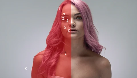 Woman with long wavy hair split between coral-red and lavender tones, with numbered overlay markers on half her face.