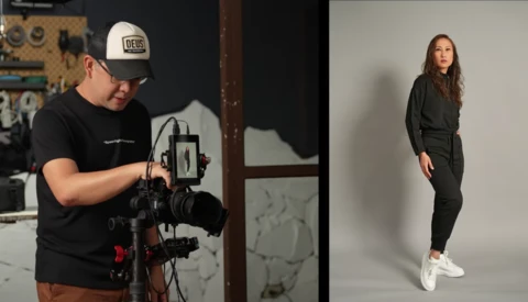 Filmmaker operating a gimbal-mounted camera system while a model poses in studio lighting.