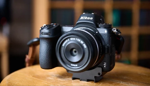 Nikon Z mirrorless camera with prime lens mounted on wooden surface.
