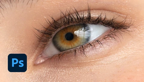 Close-up of a human eye with golden-brown iris, dark pupils, and defined black eyeliner and lashes.