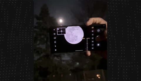 Smartphone displaying night sky photography app with moon capture overlay and manual camera controls visible on screen.