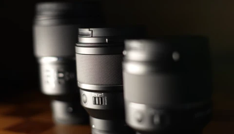 Collection of camera lenses arranged with selective focus and dramatic side lighting.