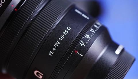 Close-up of Sony camera lenses showing RF and FE mount designations against a blue background.