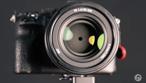 Mirrorless camera with 50mm f/1.8 prime lens mounted, displayed against dark background with studio lighting.