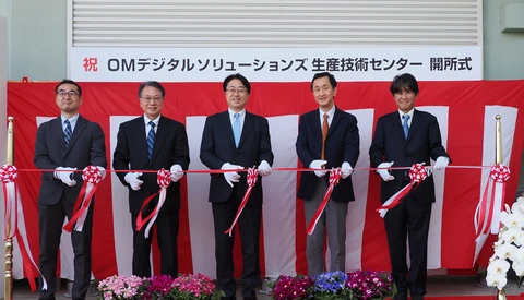 Five men in business suits cutting a red ribbon at a ceremonial opening event.