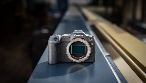 Canon EOS R5 mirrorless camera positioned on a narrow metal rail with blurred background.