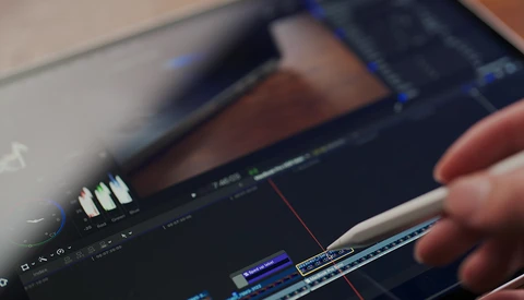 Close-up of a video editing timeline on a computer monitor with color grading adjustments visible.