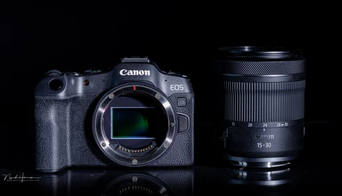 Canon EOS R5 mirrorless camera body with Canon RF 15-30mm lens against black background.