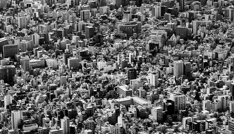 Dense urban cityscape with hundreds of tightly packed buildings viewed from above in black and white.