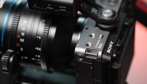 Sony mirrorless camera with cinema lens mounted, shown in close detail with shallow depth of field.
