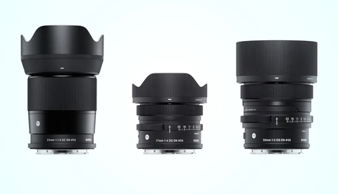 Three black camera lenses arranged in size progression from left to right against a light blue background.