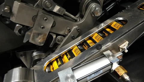 Close-up of a yellow and black coilover suspension system installed on a vehicle.