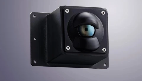 Black modular camera with spherical lens housing and adjustable mounting bracket against gray background.