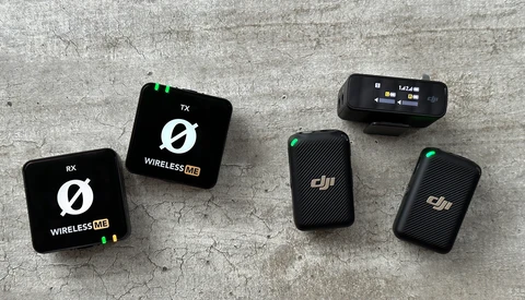 Five wireless microphone transmitter and receiver units arranged on a concrete surface.
