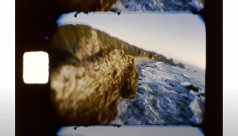 Vintage film camera viewfinder showing snowy mountain landscape with rocky terrain.