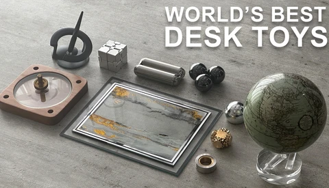 Collection of desk toys arranged on gray surface, including a spinning top, Rubik's cube, compass, magnetic balls, and antique globe.