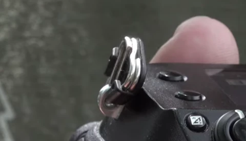 Close-up of a camera's hot shoe mount and grip detail against blurred background.