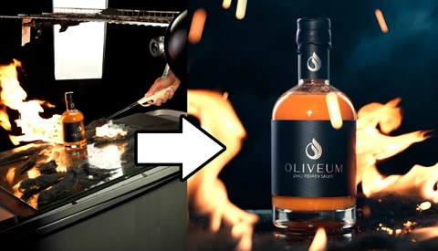 Bottle of Oliveum spirits positioned next to a dramatic studio lighting setup with flames and professional equipment.