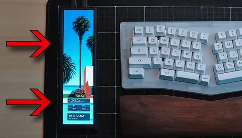 Smartphone displaying a tropical beach scene with palm trees and time stamp, positioned next to a white mechanical keyboard on a wooden desk.