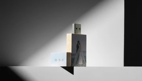 Artistic composition of a USB drive with photo printing mounted on wooden blocks against dramatic shadow lighting.