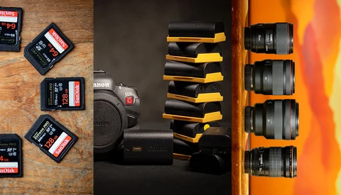 Photography gear collection including Canon camera, battery grip, multiple lenses, SD memory cards, and protective cases organized on wood surface.