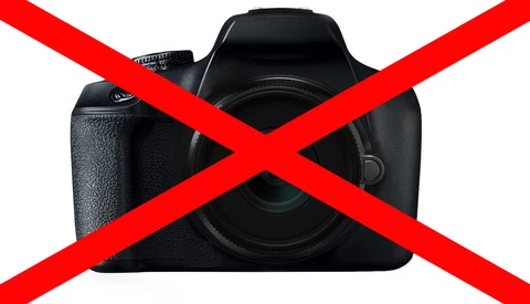 Black DSLR camera with red X overlay symbol indicating prohibition or rejection.