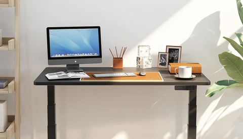 Minimalist home office desk setup with monitor, supplies, and natural window lighting.