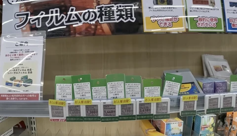 Retail shelf displaying film stock products with green and white packaging boxes arranged in rows.