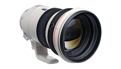 White and black telephoto lens with internal focus mechanism and rounded front element.
