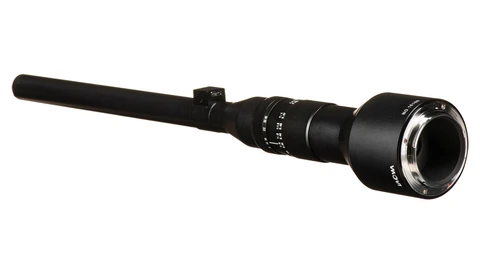 Black rifle scope with extended objective lens and adjustment turrets against white background.