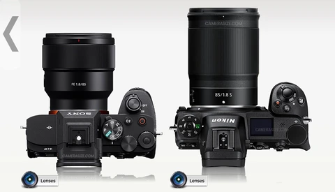 Comparison of two mirrorless camera systems with lenses mounted, shown from above against a white background.