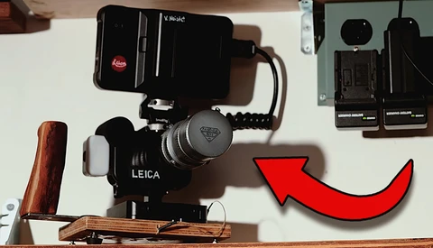 Leica rangefinder camera mounted on a wooden baseplate with a video light and external recorder setup.