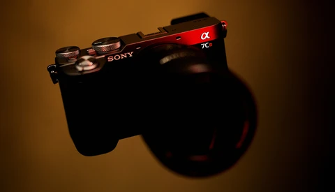 Sony Alpha 7C mirrorless camera shot from above against warm studio lighting with shadow.