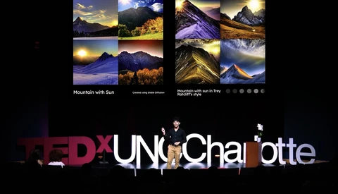 TEDxUNC Charlotte stage setup with mountain landscape photographs displayed above.