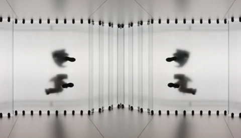 Mirrored symmetrical composition with blurred figures in motion against spiral notebook pages.