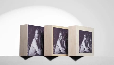 Three wooden display boxes arranged in a row, each featuring the same black and white portrait photograph of a woman.